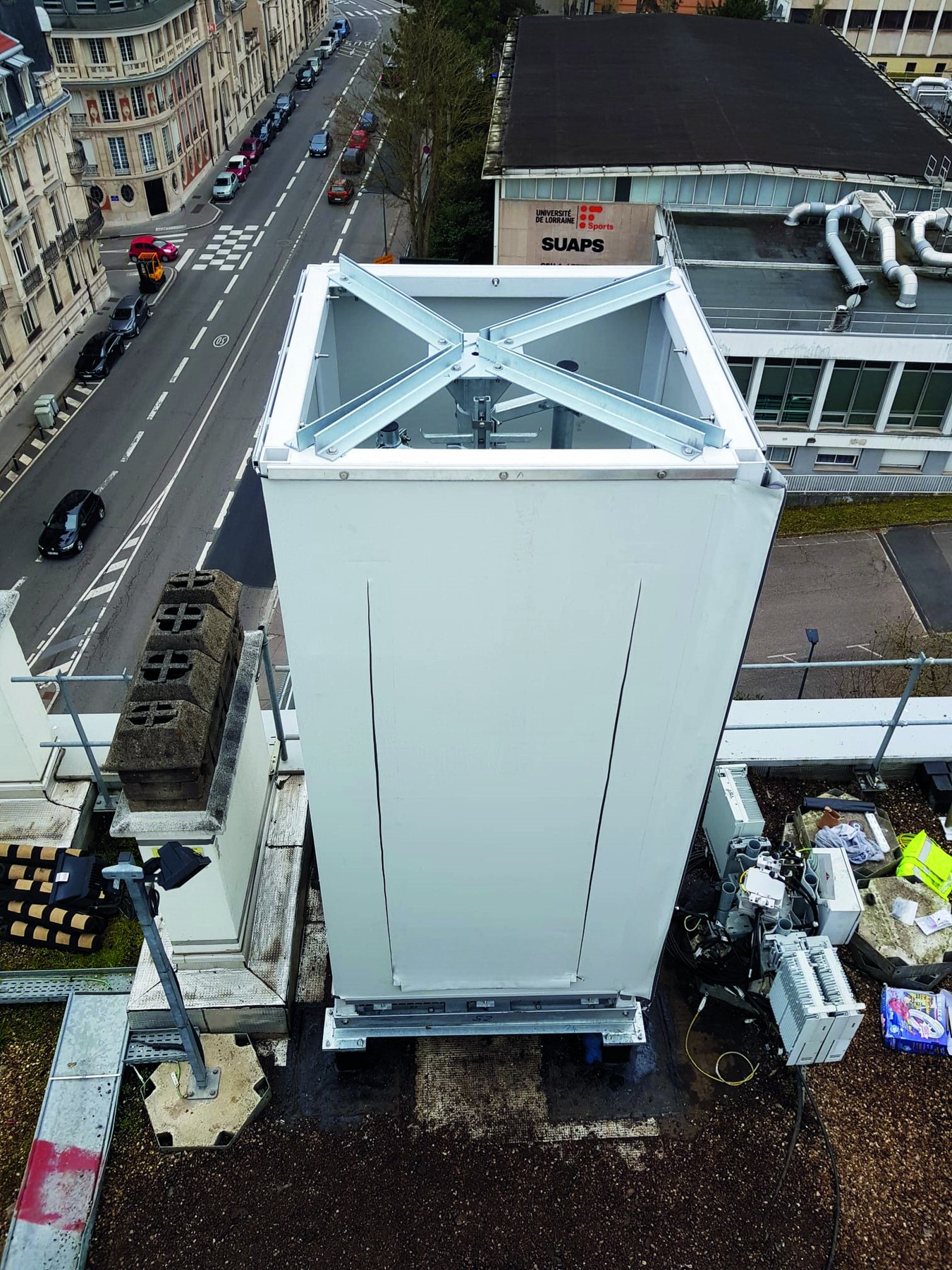 Cheminée rectangulaire en toile tendue vue du dessus sur un toit en ville