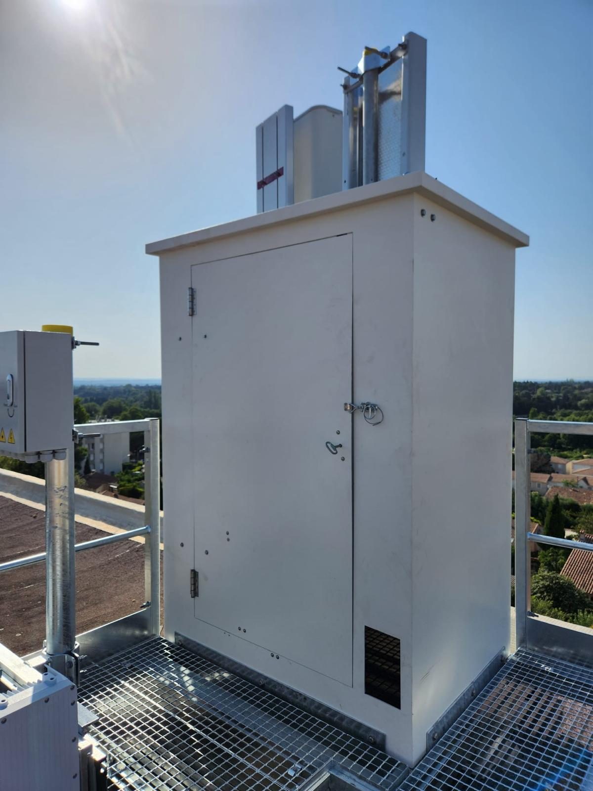 Fausse cheminée composite blanche avec porte d’accès et grille de ventilation
