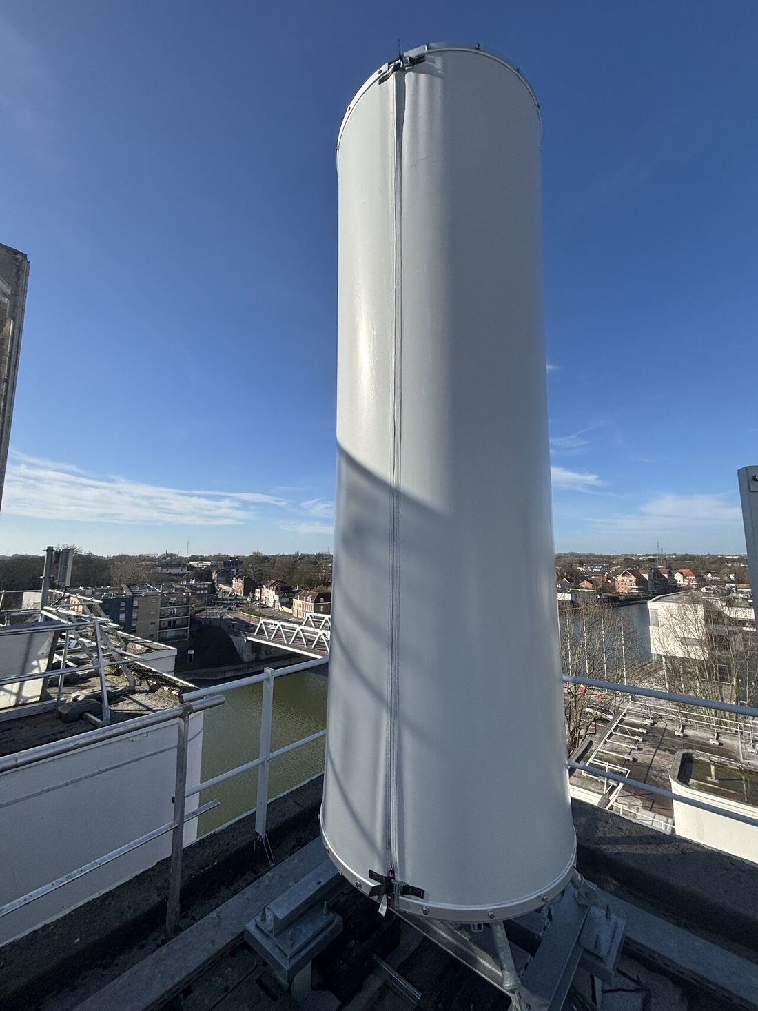 Cheminée ronde blanche en toile tendue au bord d’un canal